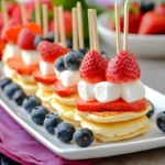 Mini pancakes skewers with strawberries, blueberries, and marshmallows, a creative and colorful way to serve mini pancakes